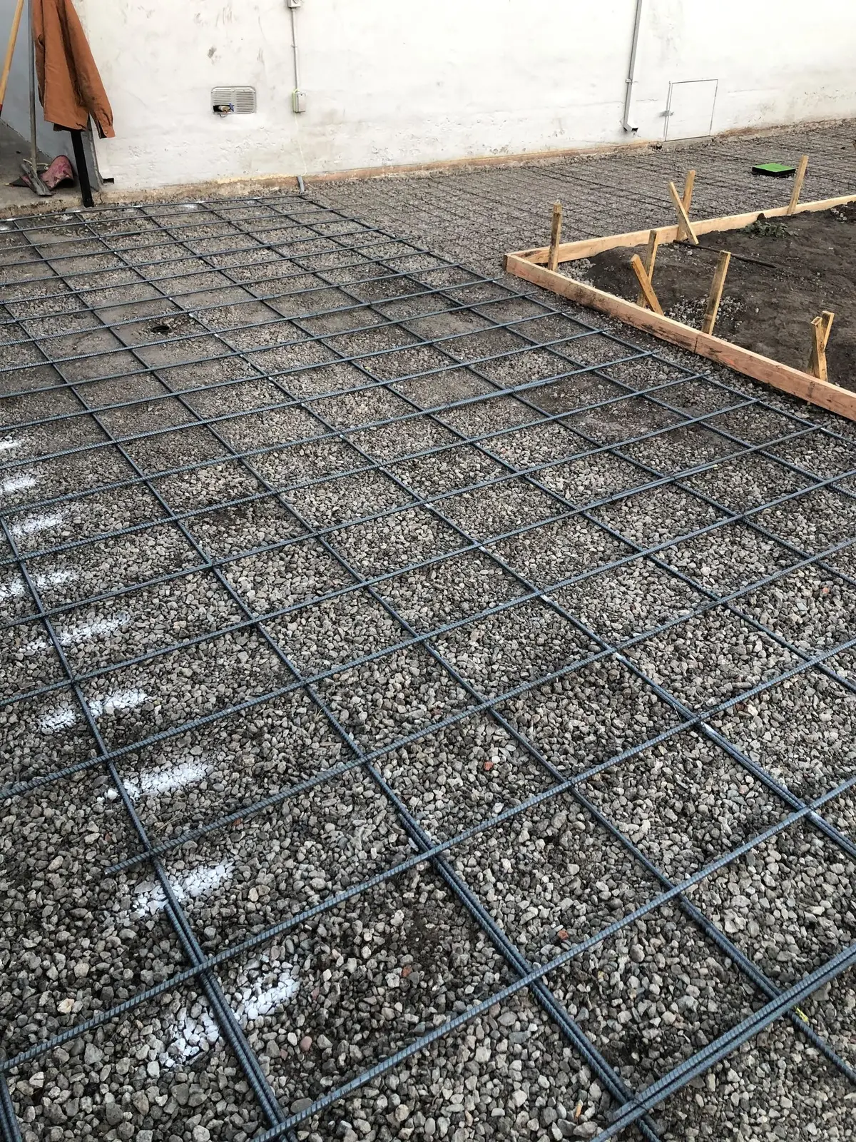 Reinforcing steel tied over a compacted gravel base before a residential concrete pour.