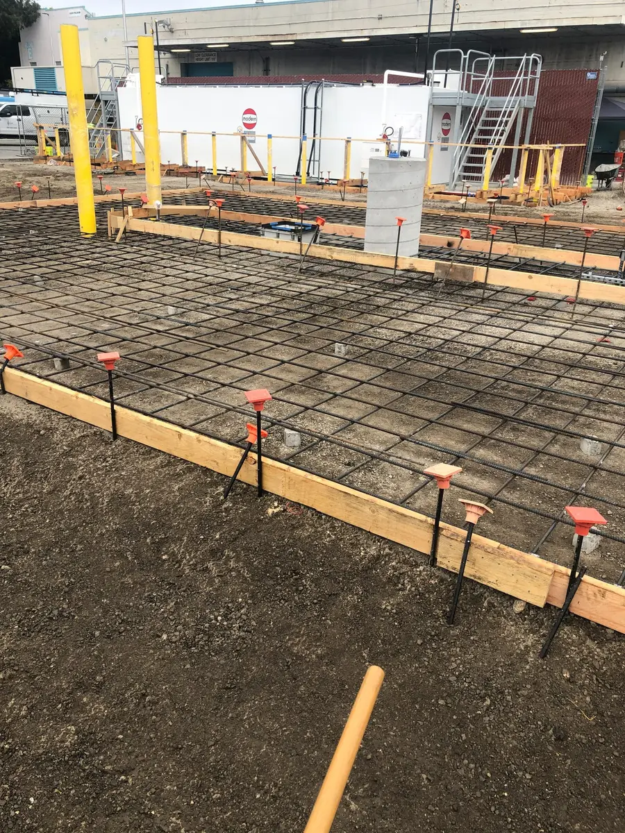 Reinforcing steel grid tied over base rock before a commercial pour.