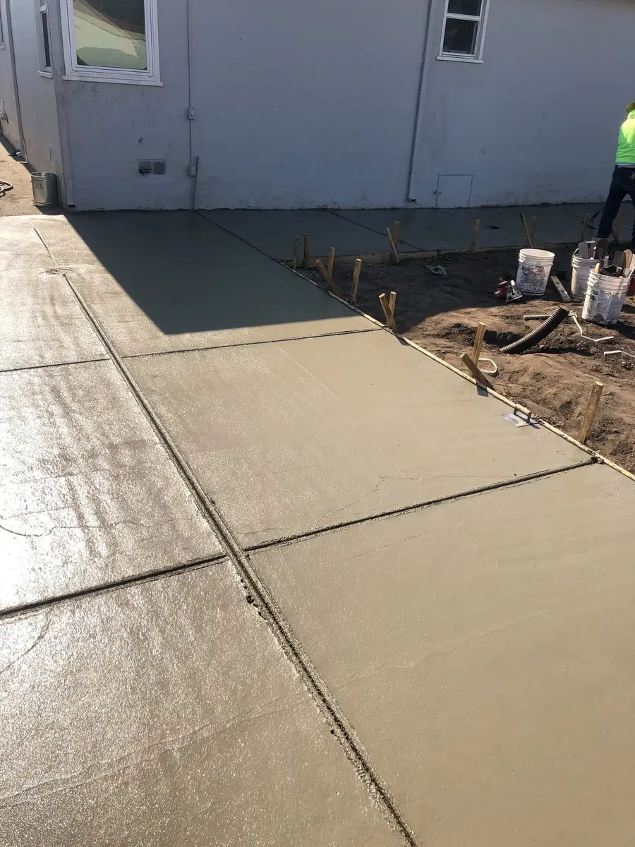 Finished concrete walkway poured alongside a house.